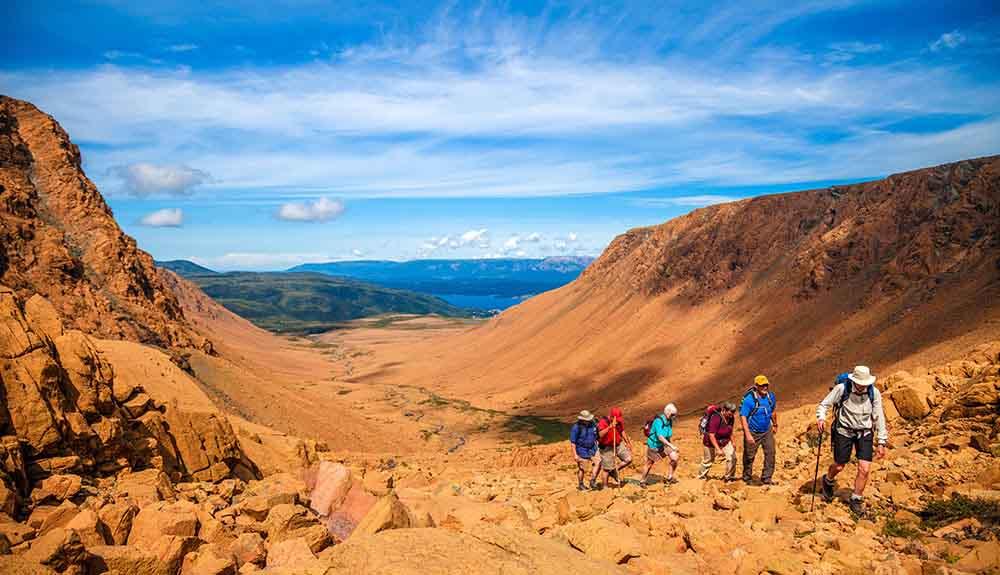 A group of hikers hiking up a rocky mountain.
