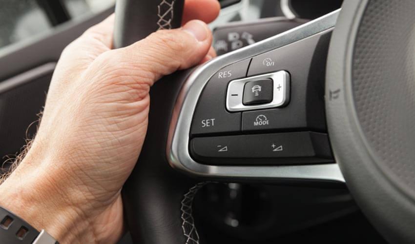 A man is holding a steering wheel in a car.