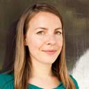 A woman in a green shirt is posing for a photo.