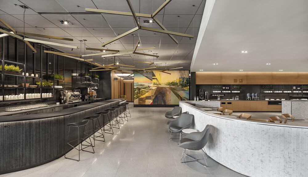 The interior of a coffee shop with a marble counter and stools.