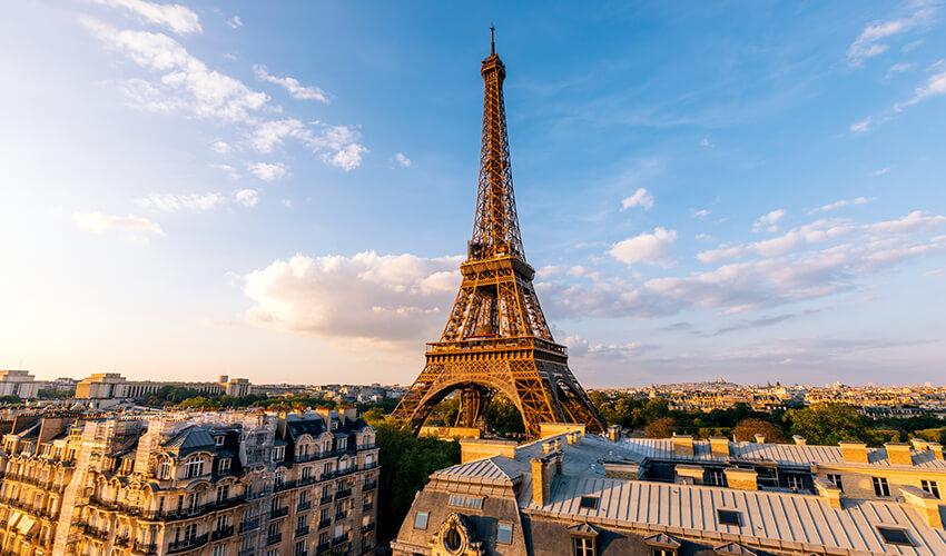 The eiffel tower stands tall against the backdrop of a sunset sky in paris.