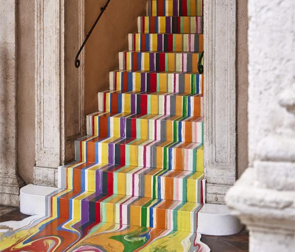 A staircase with a colorful stripe painted on it.