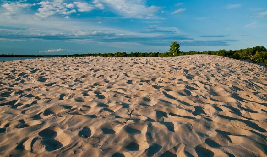 A sand dune in the middle of a lake.