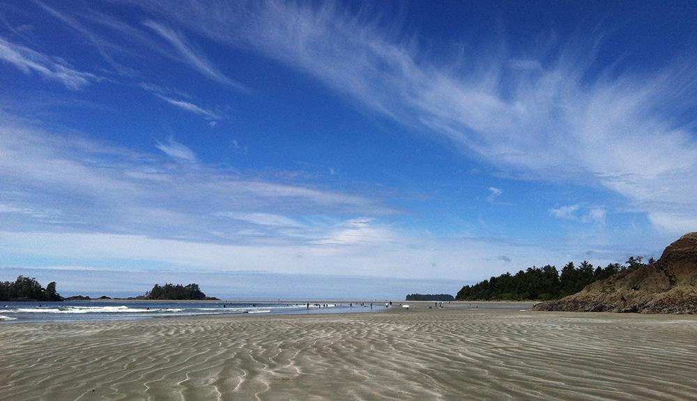 A person is flying a kite on a sandy beach.