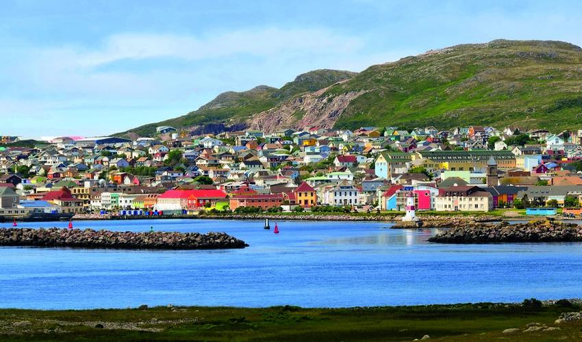 A colorful town sits on the shore of a body of water.