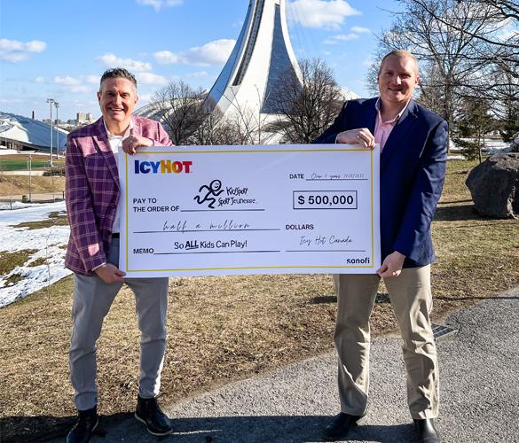 Two individuals holding a large ceremonial check for a donation of $500,000 from icyhot to kidsport.