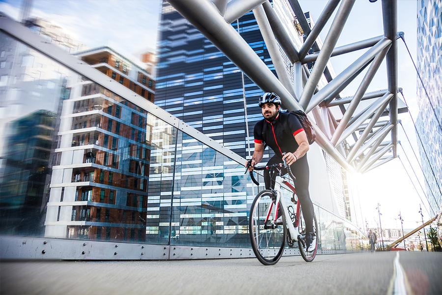 A man riding a bike on a bridge.
