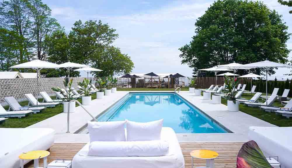 An outdoor pool with lounge chairs and umbrellas.