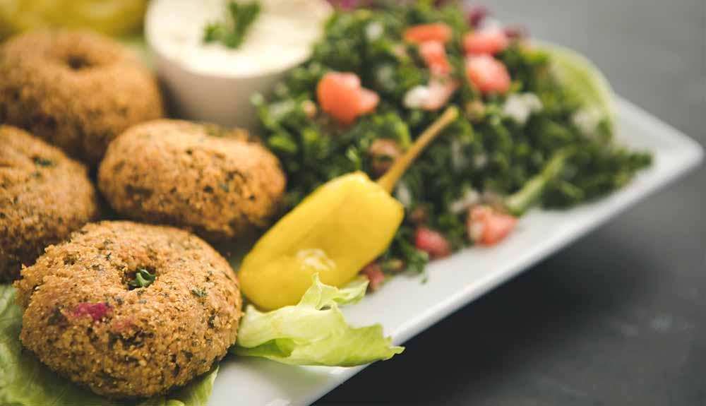 A plate of falafel, salad and vegetables.