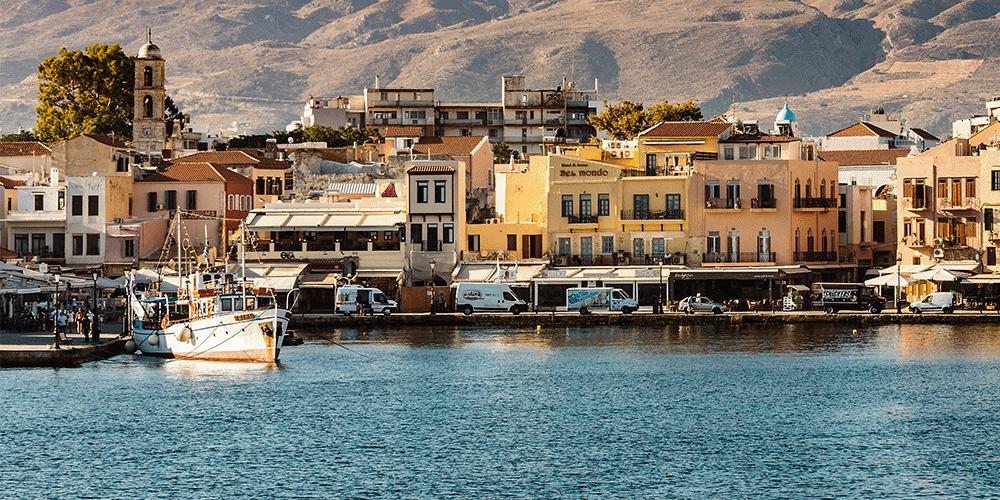 A boat docked in a harbor with mountains in the background.