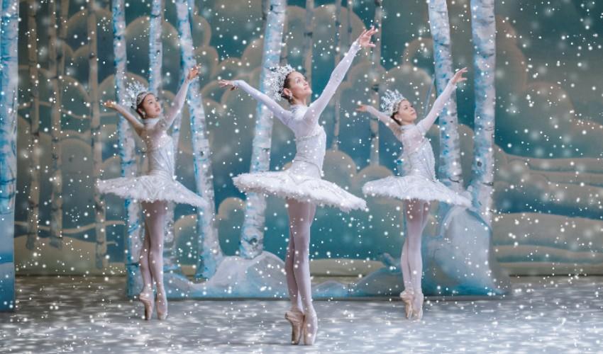 Three ballet dancers in a snow scene.