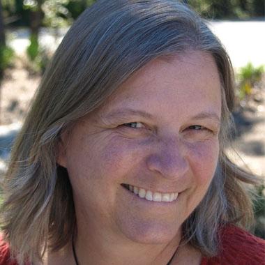 A woman with gray hair smiling for the camera.