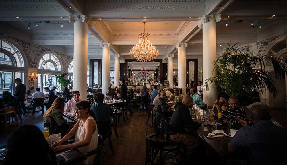 A restaurant with many people sitting at tables.