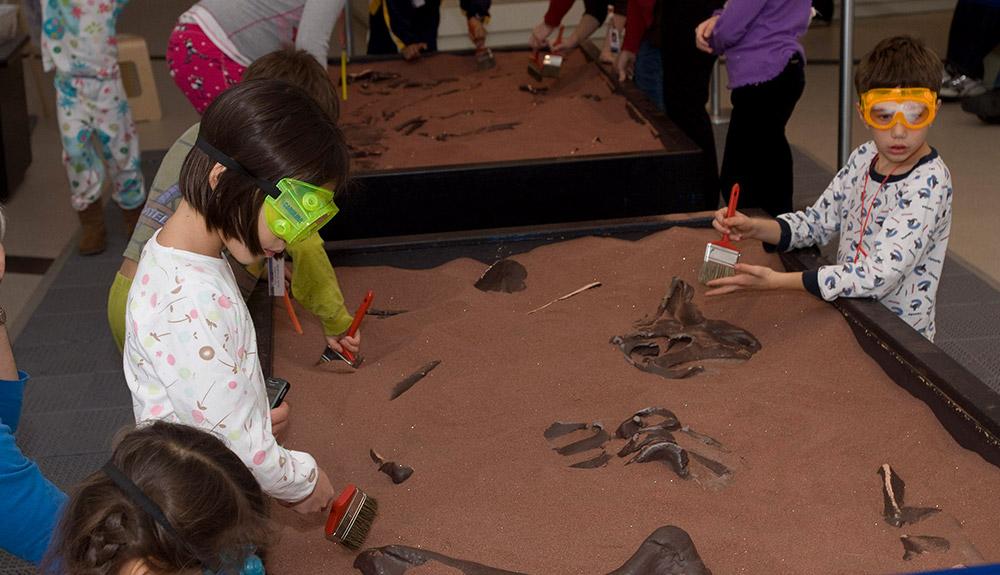 A group of children playing in a sand pit.