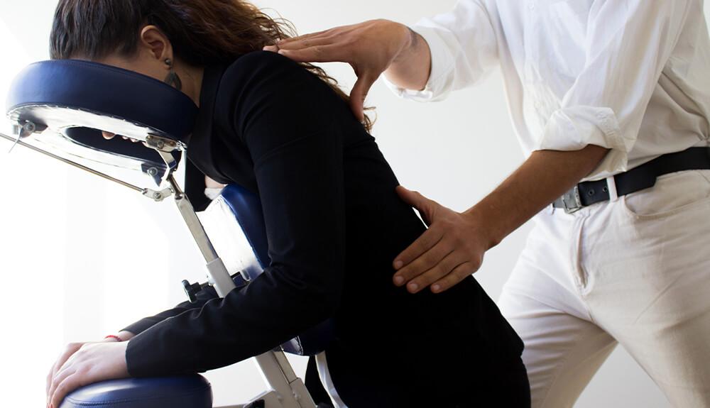 A woman is getting her back massaged by a man.
