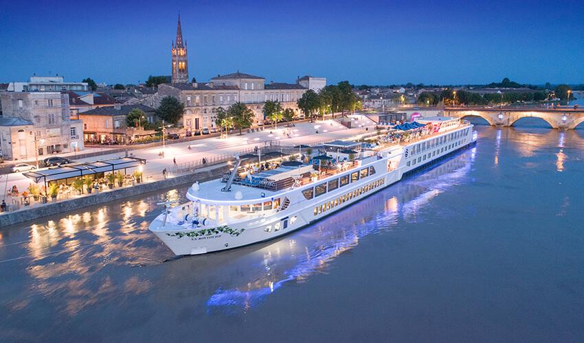 A cruise ship traveling down a river at night.
