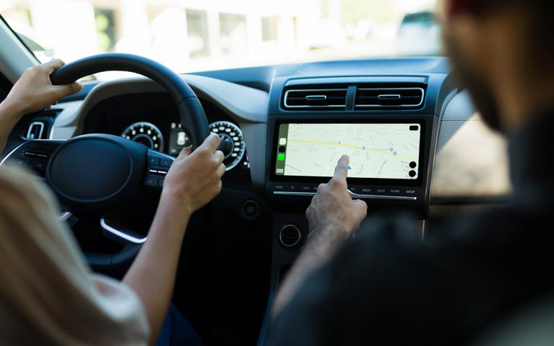 Two people in a car driving and navigating