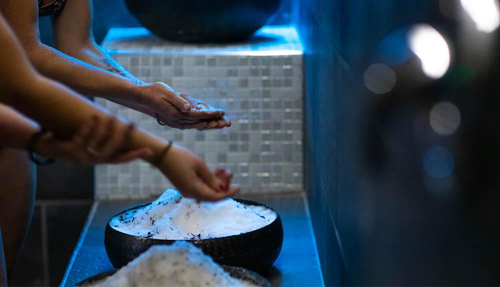 A woman is washing her hands with a bowl of water.
