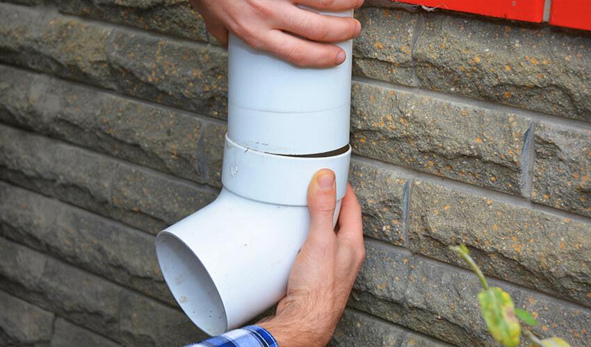 blog-img--contractors-hands -installing-rain-gutter-downspout-pipe.jpg
